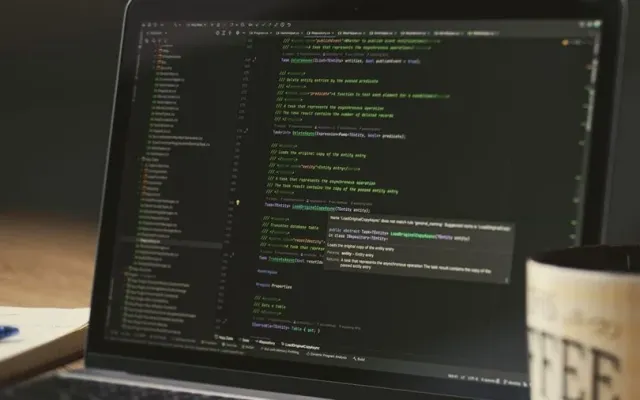 책상 위 노트북 화면에 robots.txt 설정 코드가 열려 있는 모습