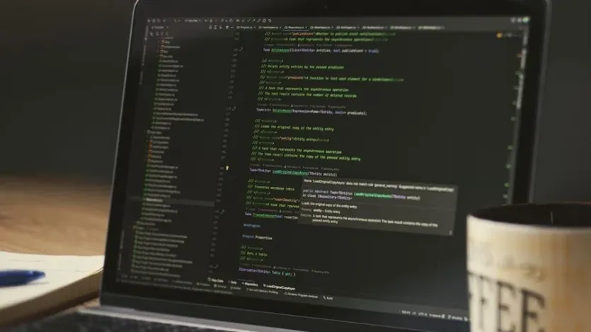 책상 위 노트북 화면에 robots.txt 설정 코드가 열려 있는 모습